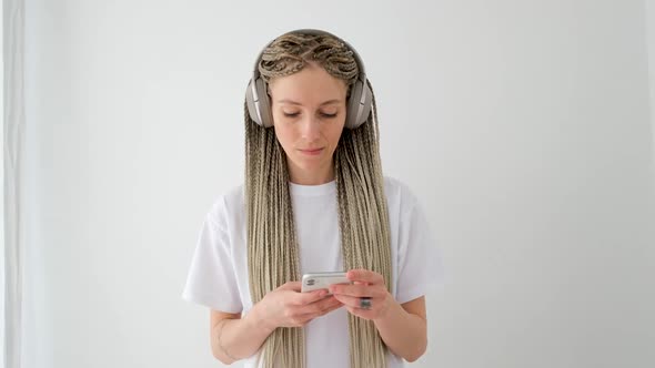 Woman in White with Pigtails Works with Smartphone