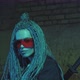 Girl with Dreadlocks and Katanas in Red Glasses Posing Against a Neon Brick Wall - VideoHive Item for Sale