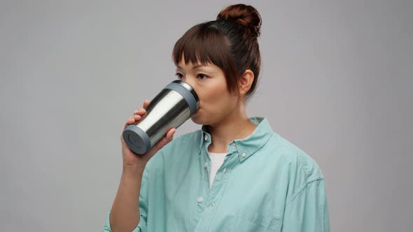 Woman with Thermo Cup or Tumbler Showing Thumbs Up