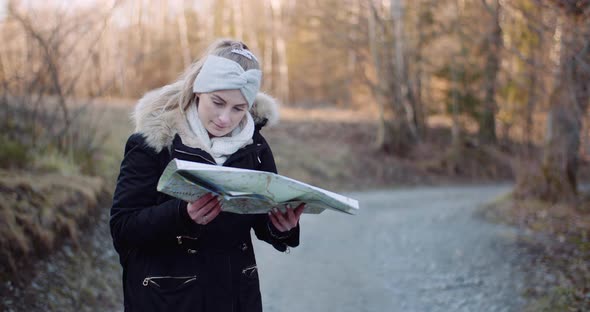 Tourist Reading Map on Trail in Mountains