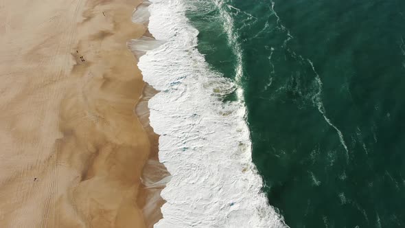 Aerial Top View of Ocean Blue Waves Break on a Beach