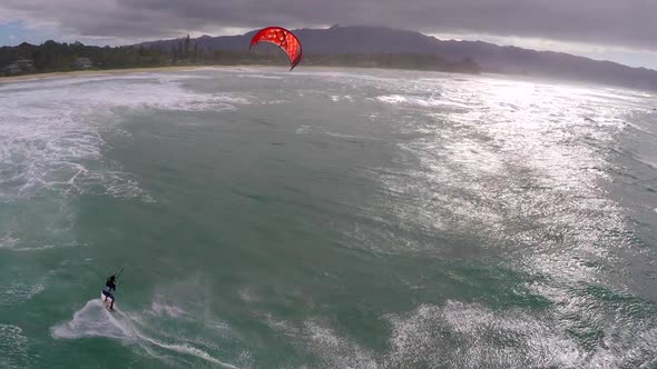 Aerial view of a man kitesurfing in Hawaii.