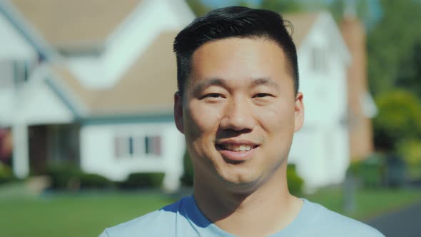 Portrait of a Young Asian Man. Smiling Looking at the Camera Against a Blurred Background at House.