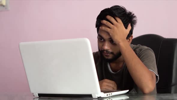 Beard man watching stock market crashing news on laptop and reacting