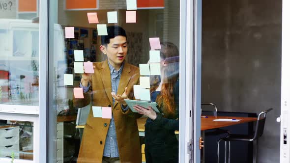 Business executives discussing over sticky notes