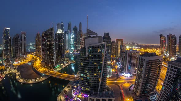 Aerial View of Dubai Marina Residential and Office Skyscrapers with Waterfront Night to Day