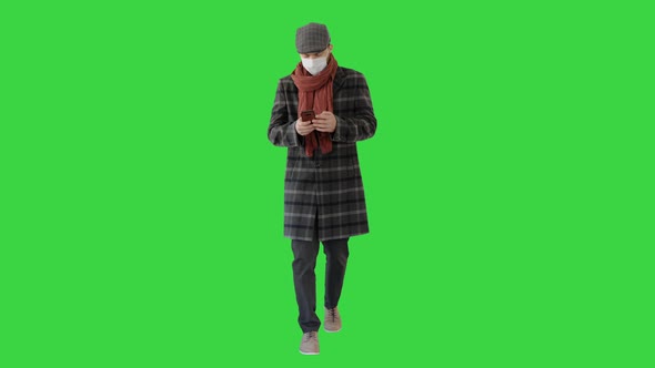 Gentleman in Medical Mask Using Phone and Walking on a Green Screen, Chroma Key.