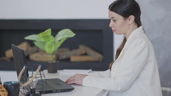 Side View of Positive Confident Woman Talking in Video Chat Using Laptop Persuading Business