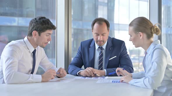 Middle Aged Businessman Having Group Discussion at Work