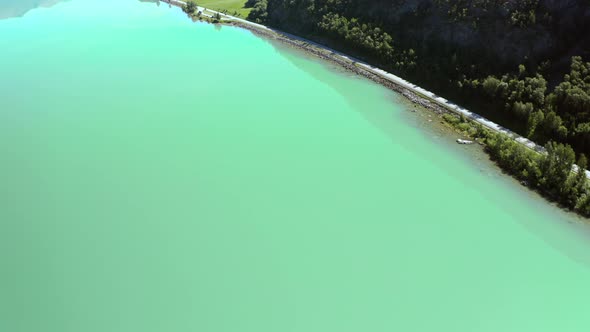 Peaceful Blue Water Of Vagavatnet Lake With Country Road At Summertime In Norway. - Aerial Drone Sho