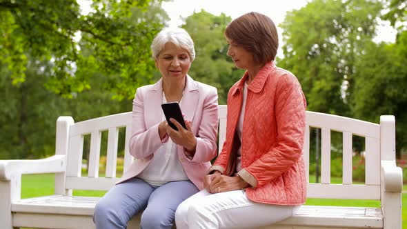 Happy Senior Women with Smartphone at Summer Park