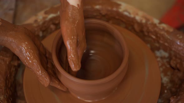 Female Hands Make Dishes From Clay on a Potter's Wheel