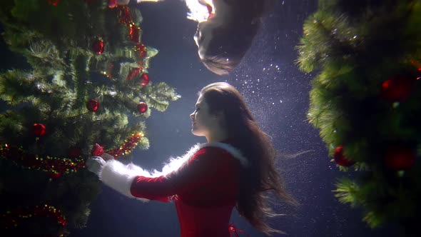 A Girl in A Red Christmas Sexy Costume, She Is Under Water on A Blue Background, Around Her Two