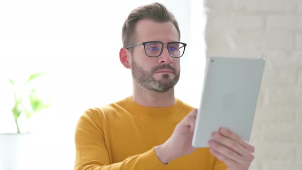 Portrait of Attractive Man Using Tablet in Office