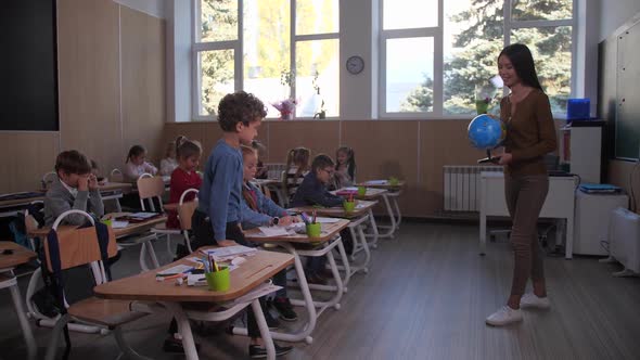 Schoolboy Raising Hand During Geography Lesson