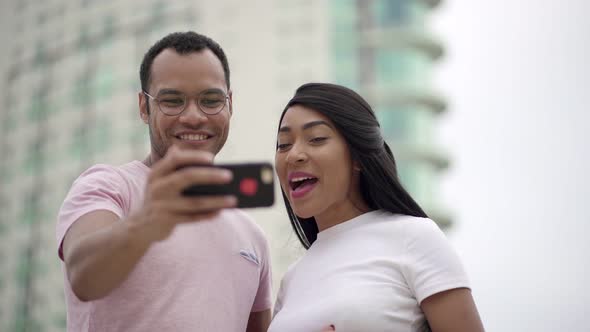 Bottom View of Cheerful Young People Talking To Smartphone