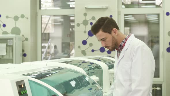 A Young Laboratory Assistant Closely Observes the Work of the Laboratory Centrifuge