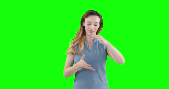 Caucasian woman raising hands on green background