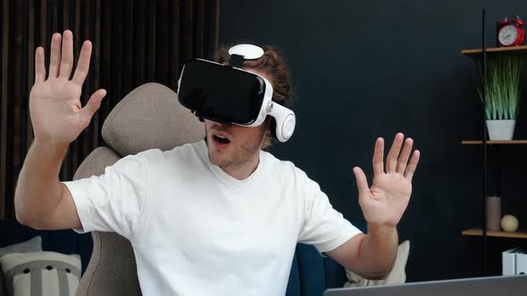 Handsome Excites Caucasian Man wearing Virtual Reality Headset at Home. Augmented Reality.