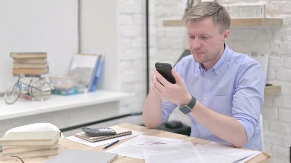 Businessman Using Smart Phone and Feeling Annoyed