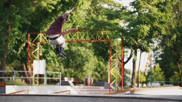 Aggressive Inline Roller Skater Doing Tricks in Concrete Skatepark Outdoors with Beautiful