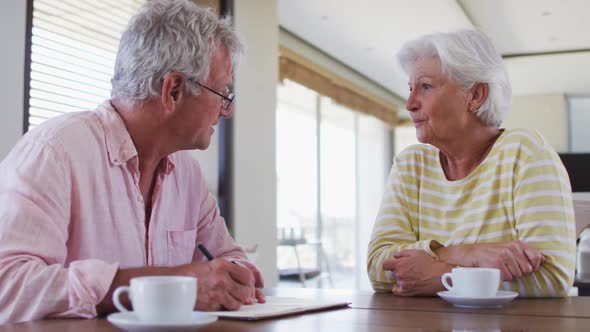 Senior caucasian couple with talking to each other discussing finances together at home