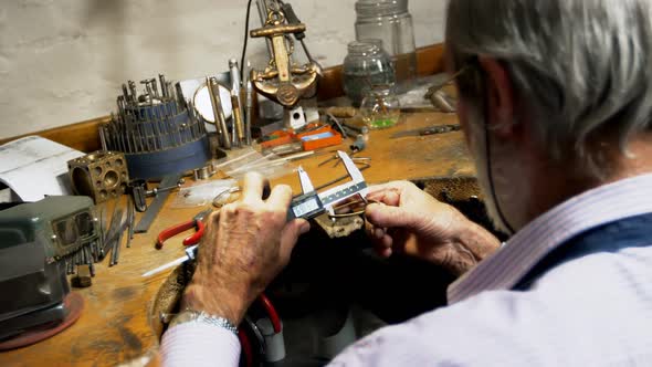 Goldsmith manufacturing jewellery in workshop