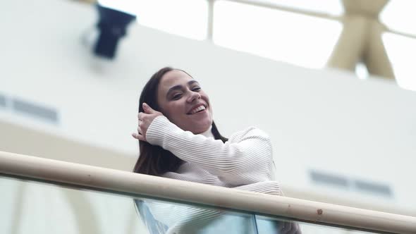 The Girl Adjusts Her Hair Against the Background of the Airport