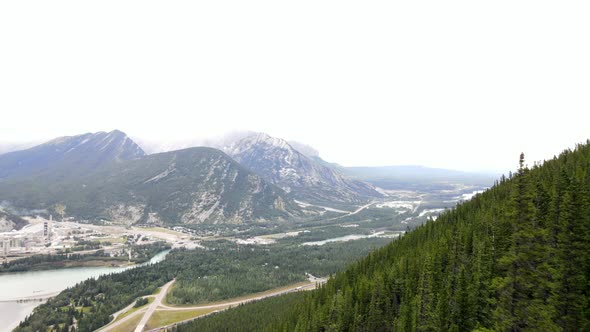 4k cinematic drone passing steep rocky slopes and coniferous forests closely. Slow aerial footage re