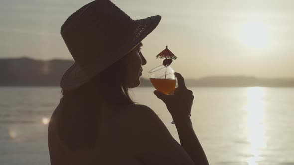 Slow Motion Video of a Girl Drinking a Cocktail at Sunset By the Sea