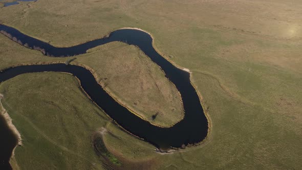 aerial view of a beautiful winding river flows among the fields, which flows picturesquely