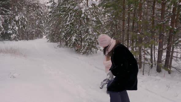 Carefree Mom and Daughter Playing To Snow Fight in Winter Forest Slow Motion