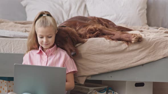 Girl with Dog Studying on Laptop