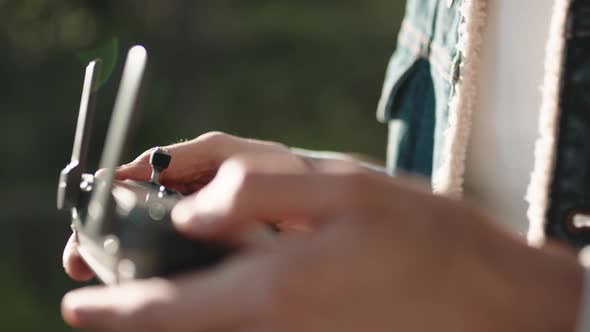 Hand of a Drone Operator Man While Pilot a Quadcopter Remote Controller