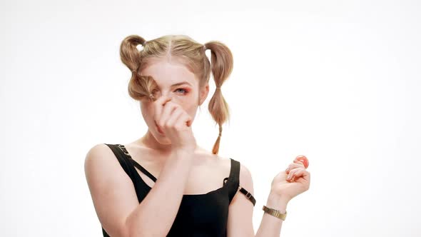 Young Beautiful Girl Smiling Winking Holding Chupa Chups Over White Background