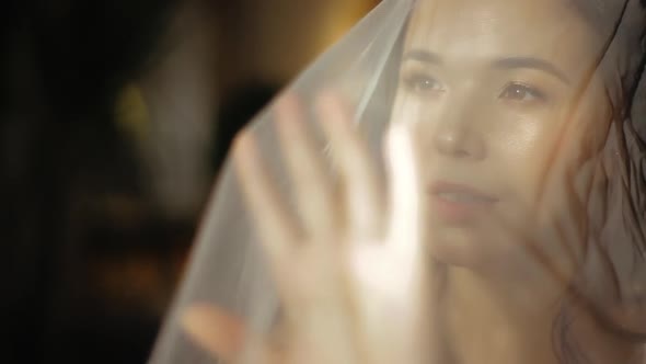 Morning of Happy Young European Bride in Wedding Veil, Slowly Pulling the Veil Forward, Close-up