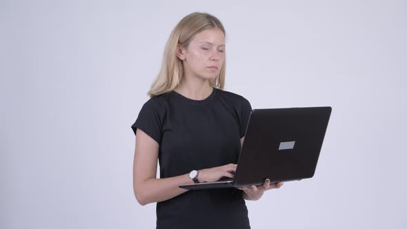 Young Happy Blonde Woman Thinking While Using Laptop