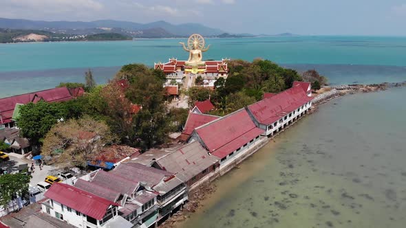Island with Buddhist Temple and Many Houses. Aerial View of Island with Buddhist Temple with Statue