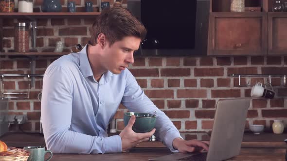 Guy Surfing Internet and Eat Healthy Food in Flat.