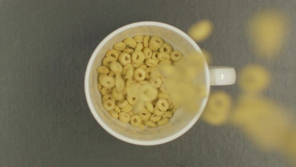 Overhead Top View of cereal rings falling in bowl in slow motion Resolution 4K Natural breakfast.