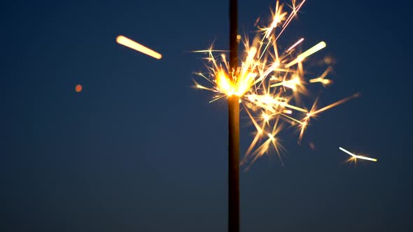 Sparkler Burning Against Evening Sky Background. Wand of Bengali Fire for Christmas