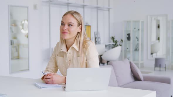 Attractive woman with laptop interviewing colleague in white room