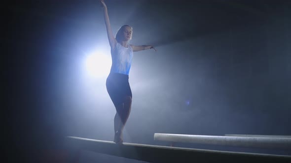 Training of Young Female Gymnast on Balance Beam in Sportive Hall Preparing to Competition