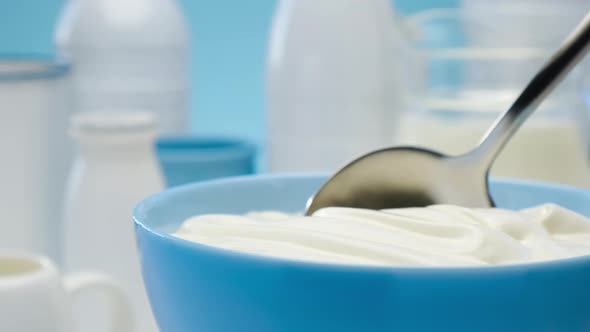 Bowl of sour cream on blue background, greek yogurt