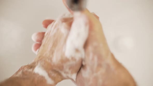 Caucasian man washes hands with water, high angle close up slow motion