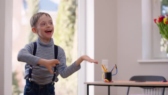 Carefree Cheerful Autistic Boy Dancing Laughing on the Left Indoors