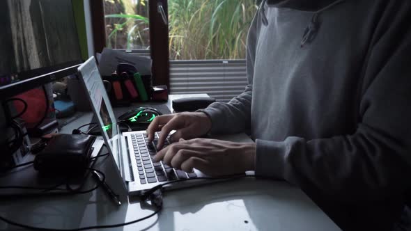 Male in home office setting. Typing on computer