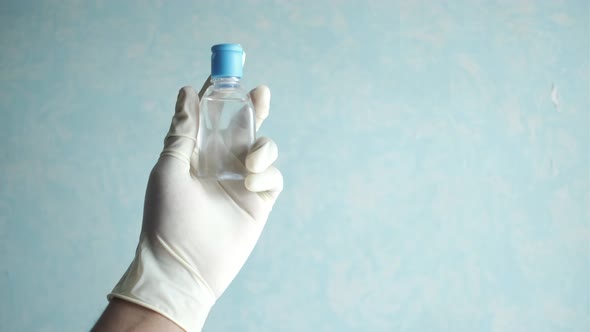 Hand in Latex Gloves Holding Hand Sanitize with Copy Space