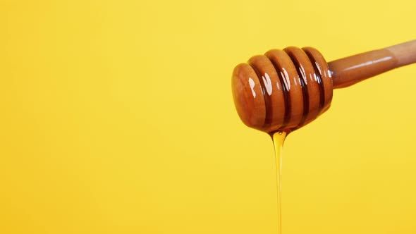 Close Up of Fresh Honey with Spoon Against Yellow Background