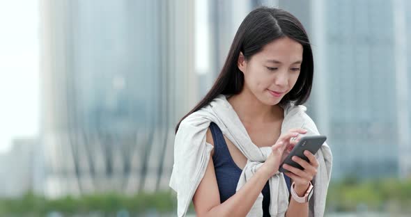 Woman use of mobile phone for sending message at outdoor